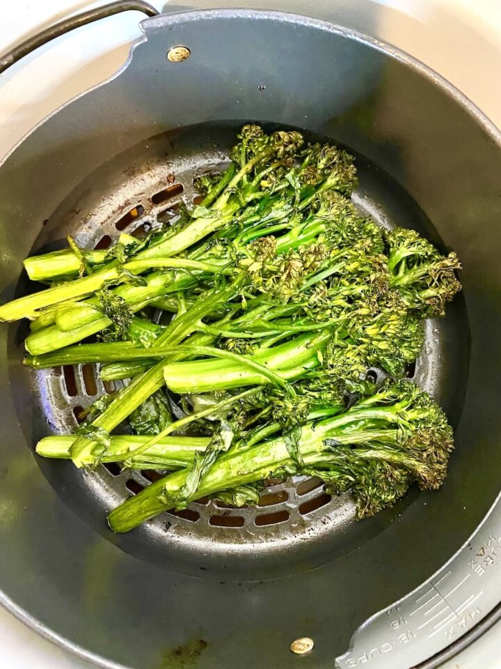 cooked broccoli in a Ninja Foodi air fryer basket