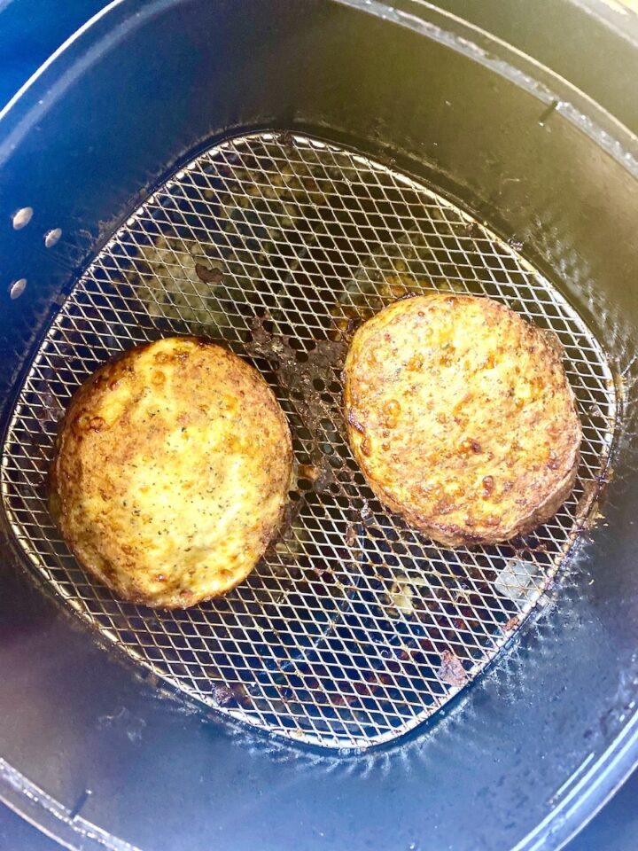 Cooked chicken burger in air fryer basket
